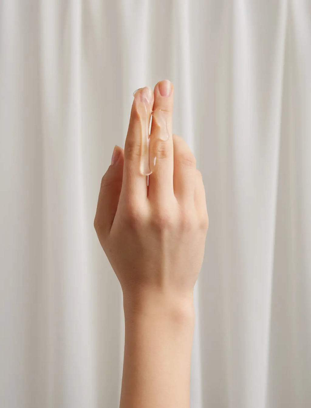 Hand displaying the texture of the lubricant against a plain background